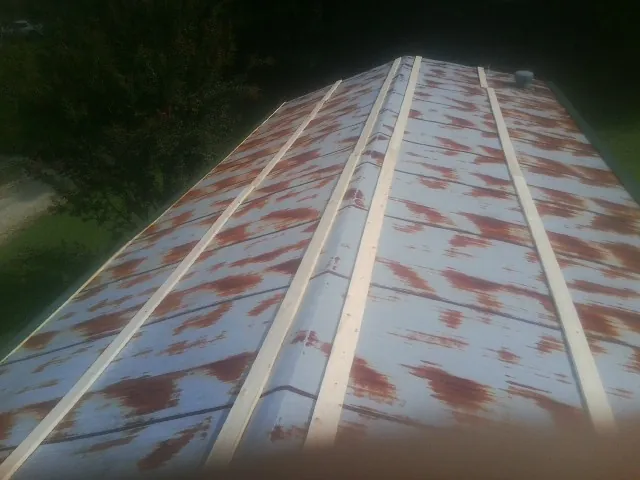 Rusted metal roof panels with new wood purlins before replacement — Storm Damage Roof Repair in Sherman by Roofing Brothers